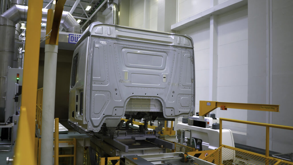 Truck body at factory. Scene. Frame of truck is moving on rails of factory. Modern equipment at